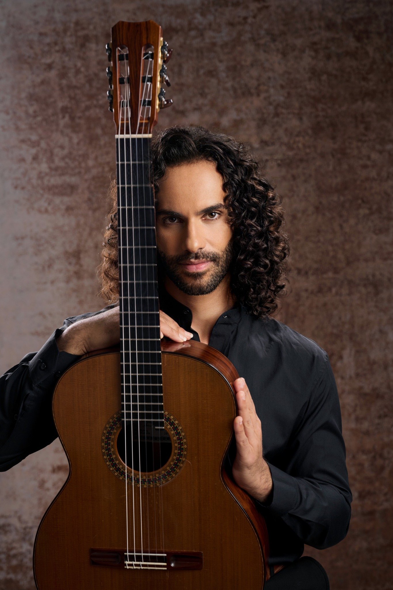 Classical guitarist Brett Gómez holding his guitar